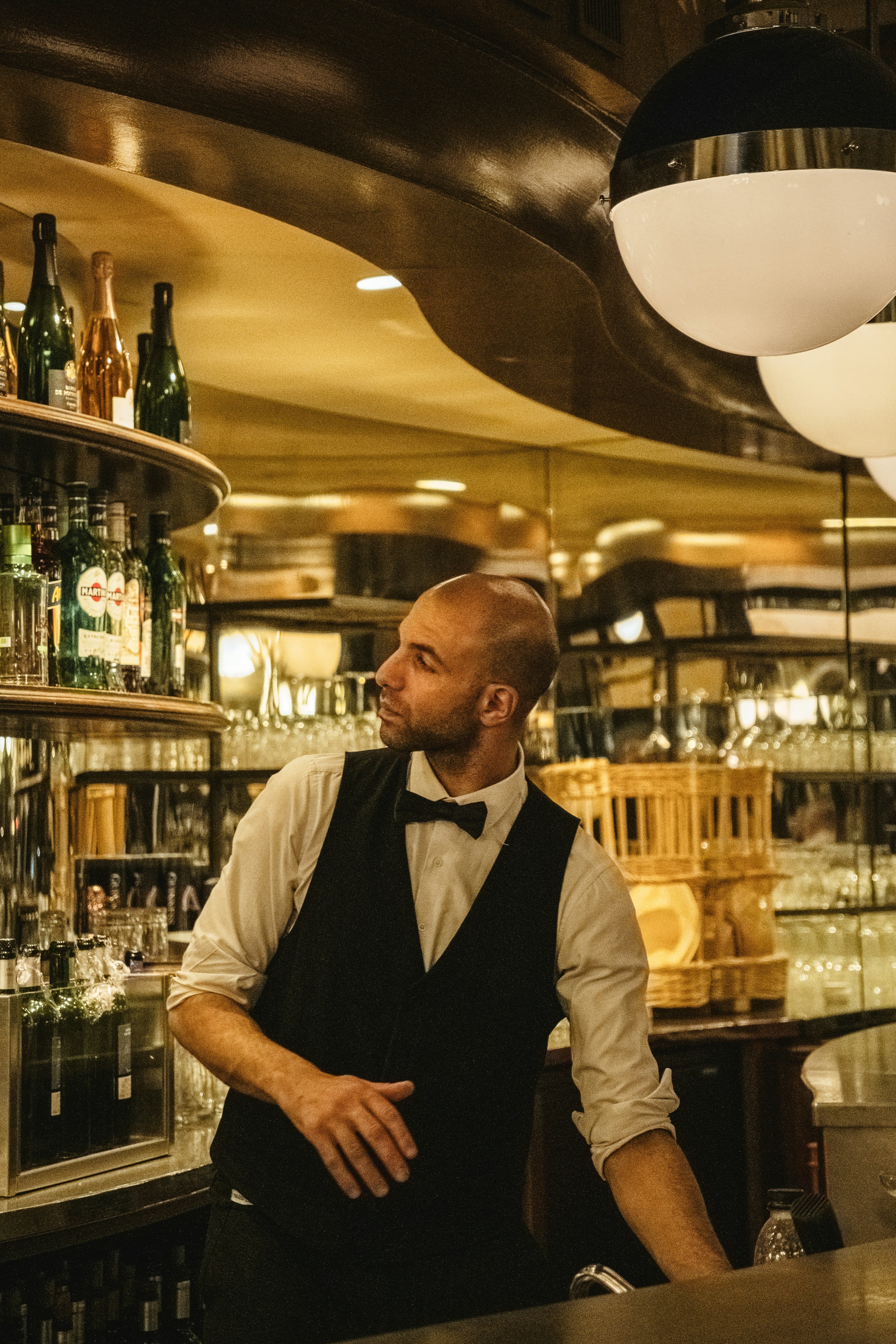 Barman / Barmaid en intérim — Barman en tenue derrière le comptoir d'un bar de restaurant